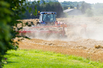Fototapeta premium Tracteur dans un champ de blé après la moisson