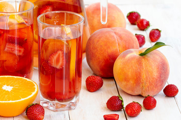 Two fresh cocktails on Light background. Glass of strawberry soda drink. Dietary detox drink with peach, strawberry, orange, lemon. Healthy berry fruit cocktails. Ice cold summer cocktail or lemonade.
