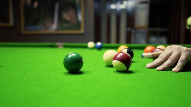 Man taking one shot at a billiard table