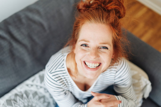 Cute mischievous young redhead woman grinning