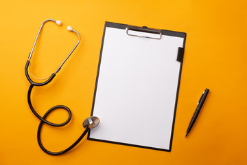 Stethoscope in doctors desk with tablet, pen and pills