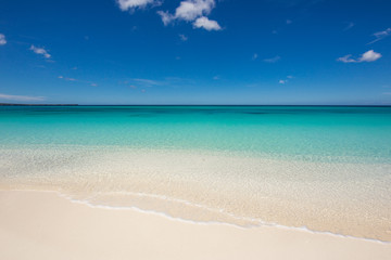 Fototapeta na wymiar Beautiful beach with white sand and crystal clear water. No one around. Wave in the sand and blue sky. Atlantic Ocean, Dominican Republic