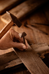 man driving a nail on a wooden cross.