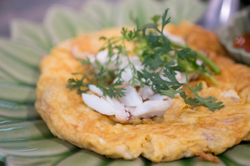 Omelette with crab meat on a green plate
