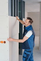 Fototapeta na wymiar Handyman installing wall cladding in a new house