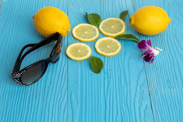 sommer concept lemon and glasses on blue wood background
