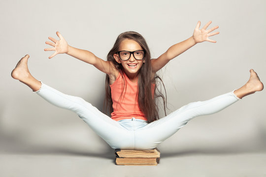 Waiting for the rest concept. Portrait of a happy funny girl after sitting on manuels with legs and hands up over light gray background in summer season casual clothing. Studio shot - Powered by Adobe