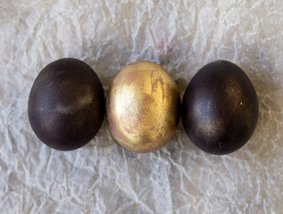 Black and gold eggs on white background. Easter holiday concept. Selective focus, copy space, close up.