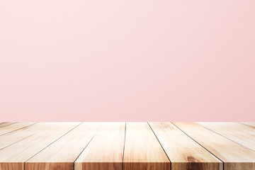 Empty wooden deck table over rusty pink background for present product.