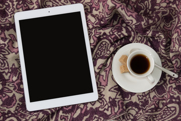 Fototapeta na wymiar Tablet with a cup of coffee. Elegant and cozy feminine background, concept for advertisement.