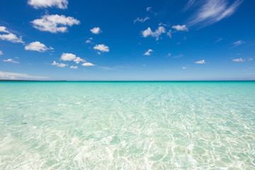 Fototapeta na wymiar Horizon line with crystal clear water of the Caribbean Sea and blue sky with clouds. Calm and relaxation. Beautiful background. Dominican Republic, Barahona Bahia de las Aguilas. Best beaches 