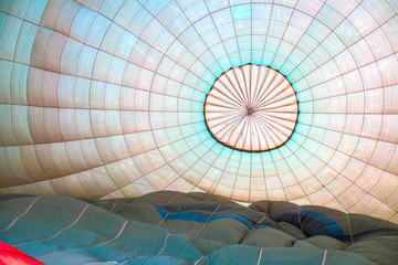 Hot air balloon's dome inside while it filling with air. Soft pastel colors.