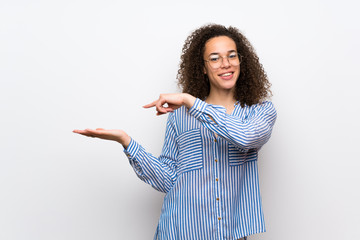 Dominican woman with striped shirt holding copyspace imaginary on the palm to insert an ad