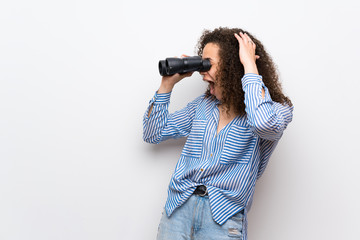 Dominican woman with striped shirt and looking in the distance with binoculars