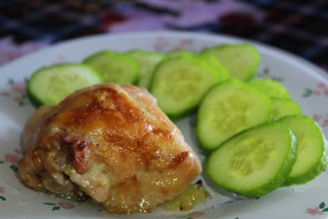 on plate slice of chicken fried meat and cucumber