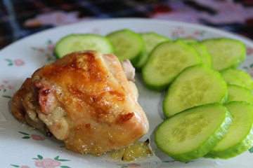 on plate slice of chicken fried meat and cucumber