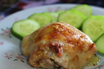 on plate slice of chicken fried meat and cucumber