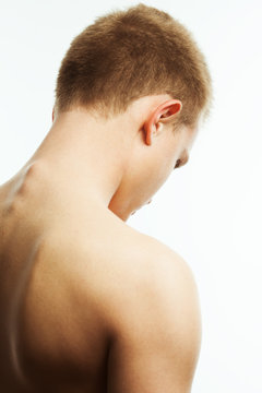 Art concept of natural male beauty. Close up portrait of handsome charismatic young man's back posing over white background. Avant-garde style. Studio shot