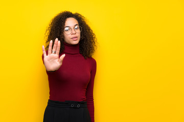 Dominican woman with turtleneck sweater making stop gesture denying a situation that thinks wrong