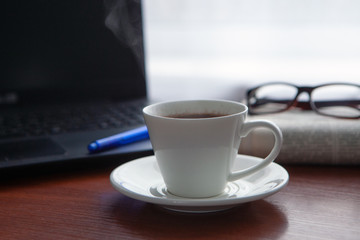 Newspaper with computer on table. Coffee break.
