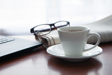 Newspaper with computer on table. Coffee break.