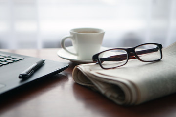 Newspaper with computer on table. Coffee break.
