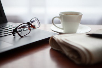Newspaper with computer on table. Coffee break.