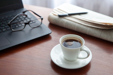 Newspaper with computer on table. Coffee break.