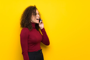 Dominican woman with turtleneck sweater keeping a conversation with the mobile phone