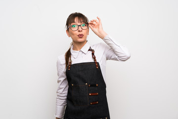 Young woman with apron with glasses and surprised