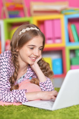 Portrait of emotional cute girl using laptop