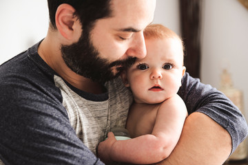 A Nice and protect father with baby on bed