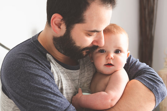 A Nice and protect father with baby on bed