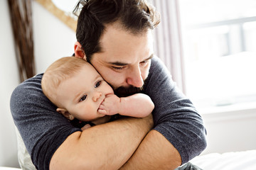 Fototapeta premium A Nice and protect father with baby on bed