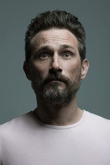 Obraz premium Fabulous at any age. Portrait of shocked 40-year-old man standing over dark gray background. Close up. Classic style. Scar on forehead. Studio shot