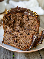 Amazing Chocolate Easter Cake with chocolate drops and dry cherries on an old wooden background with black and golden eggs. Slice of cake. Easter concept. Selective focus, close up.