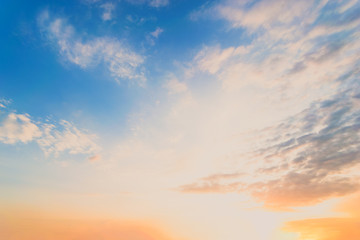 Sky blue and orange light of the sun through the clouds in the sky