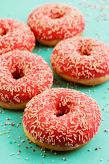 Donuts decorated with icing on blue background.