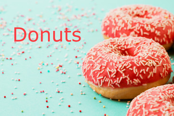 Donuts decorated with icing on blue background.