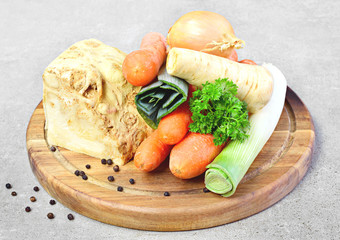 Soup vegetables, cooking scene. Broth ingredients, celery, parsley, leek and carrots on a wooden cutting board.