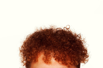 Vertex of young man with red hair posing over white background. Close up. Copy-space. Studio shot