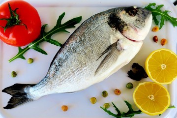 sea fish with spices, red tomatoes, lemon and herbs