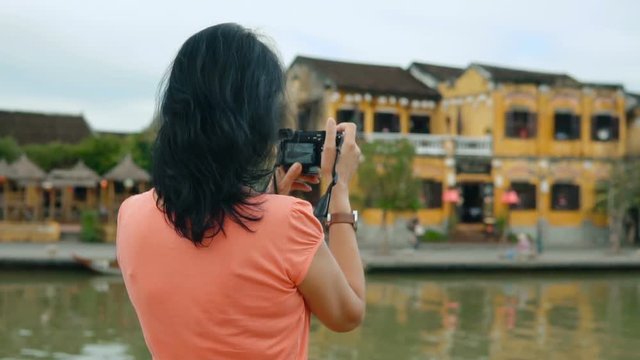 Attractive woman taking pictures of beautiful city views in Vietnam. Slow motion people footage.