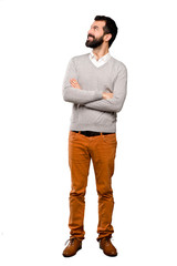 Handsome man looking up while smiling over isolated white background