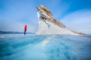 Dragon rock and traveller man in red cloth with blue sky at Ogoy island, Baikal lake, Russia