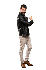 Naklejka premium Handsome man with beard pointing back over isolated white background