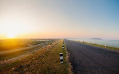 Landscaped walkway around a meadow at sunset sky change from blue to orange,Walkway with stunning views for jogging.