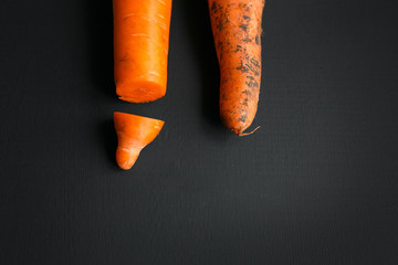 Creative work on male circumcision. Clean pruned carrots and dirty carrots lying on the table. Carrot symbolizes male penis.
