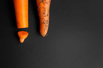 Creative work on male circumcision. Clean pruned carrots and dirty carrots lying on the table. Carrot symbolizes male penis.