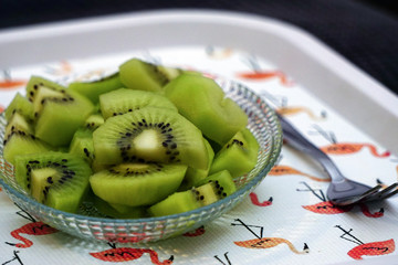 Sliced kiwi fruit on glass bowl close up view